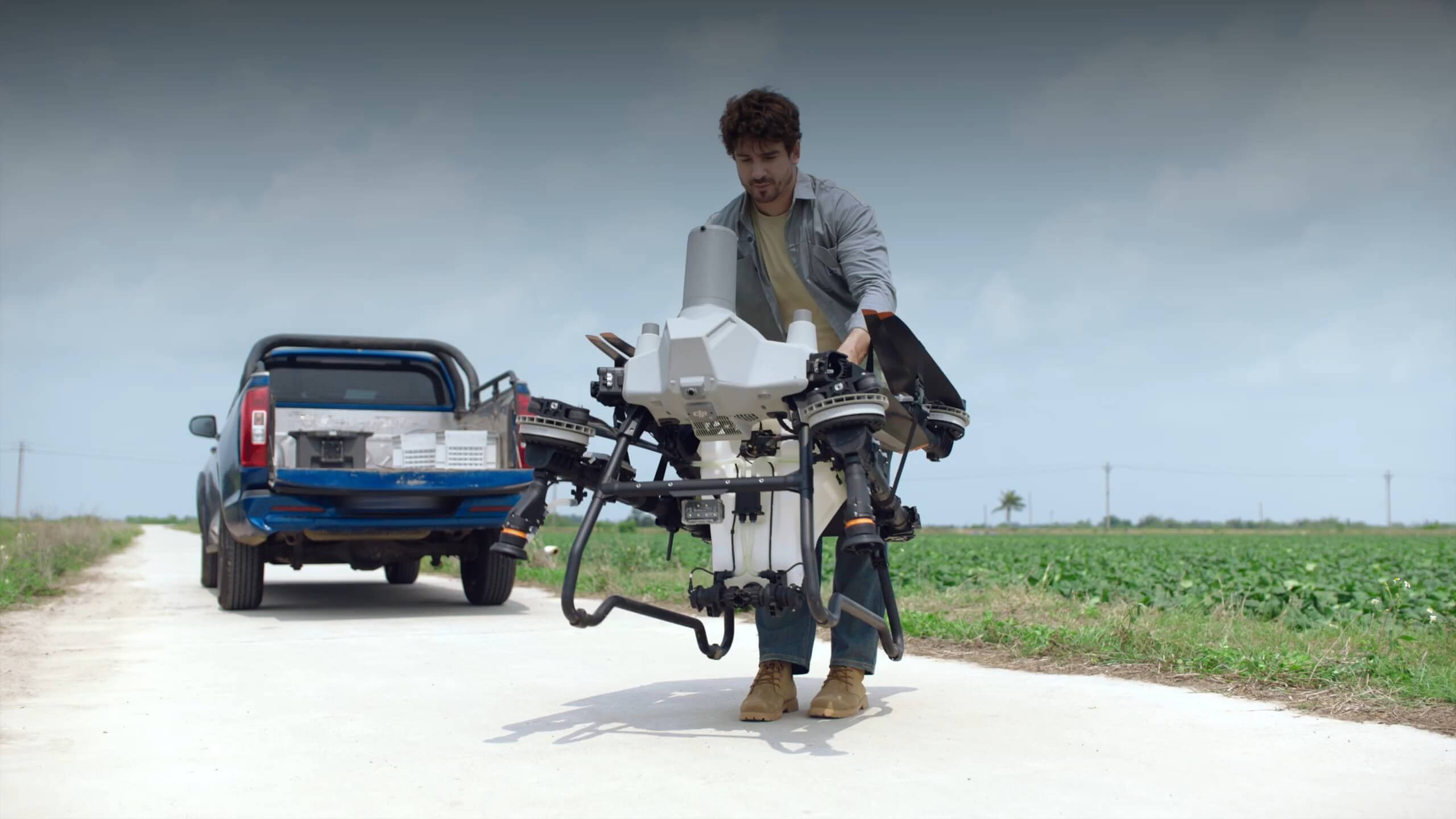 Operador cargando un DJI Agras T55 plegado en la caja de una camioneta