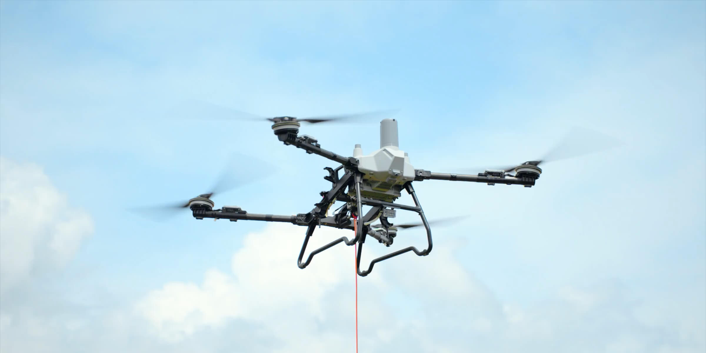 DJI Agras T55 izando una carga con el sistema DL100