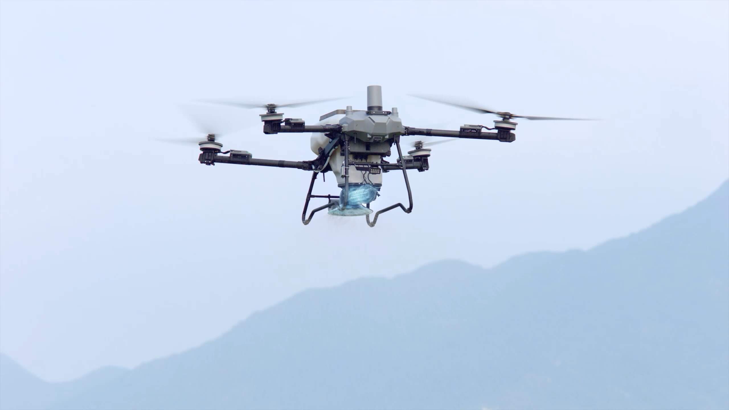 DJI Agras T70P izando una carga con cable